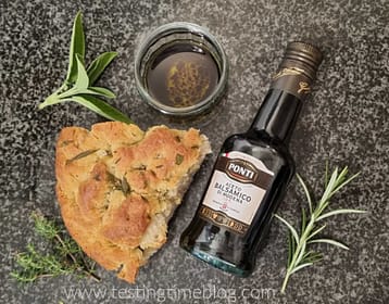 Ponti Balsamic Vinegar Of Modena with a large wedge of homemade focaccia, rosemary, thyme and sage.